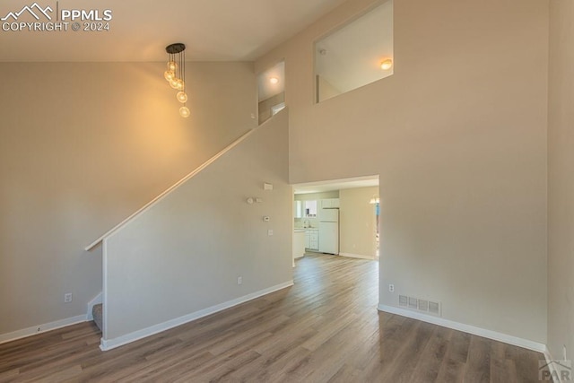 unfurnished living room featuring hardwood / wood-style floors and high vaulted ceiling