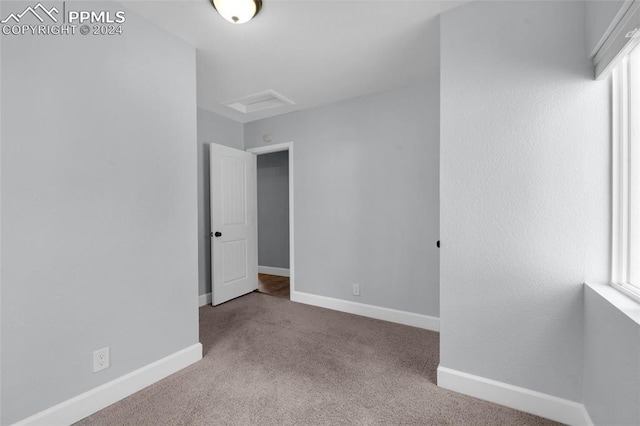 unfurnished bedroom featuring light carpet and multiple windows