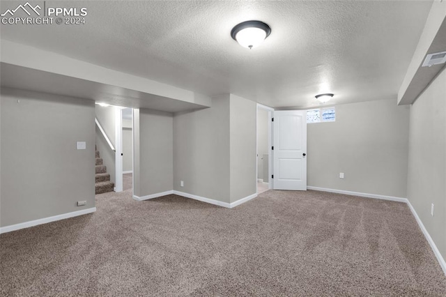 basement featuring carpet and a textured ceiling