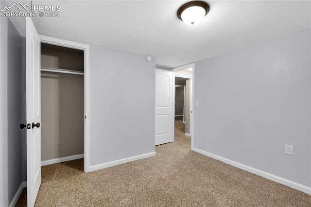 unfurnished bedroom featuring light carpet and a closet