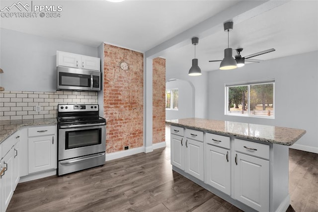 kitchen with light stone countertops, ceiling fan, dark wood-type flooring, stainless steel appliances, and white cabinets