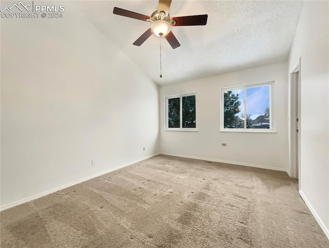 carpeted empty room with ceiling fan, a textured ceiling, and vaulted ceiling