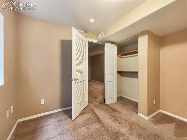 unfurnished bedroom with carpet floors and a closet