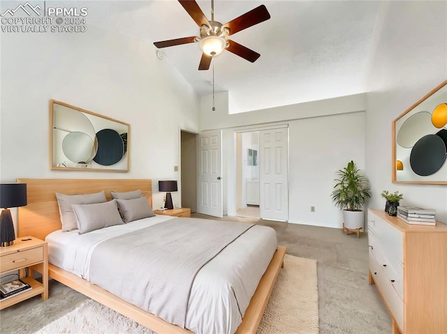 carpeted bedroom featuring high vaulted ceiling and ceiling fan