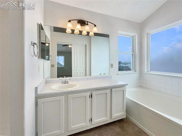 bathroom featuring a bathing tub, ceiling fan, vanity, and lofted ceiling