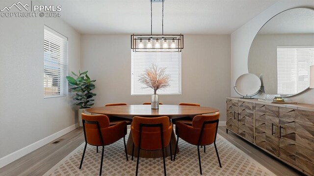 dining room featuring light wood-type flooring and an inviting chandelier