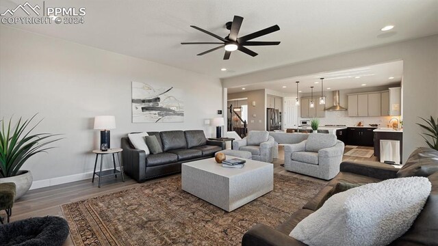 living room with ceiling fan and dark hardwood / wood-style flooring