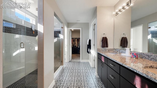 bathroom with tile patterned floors, a shower with door, vanity, and a healthy amount of sunlight