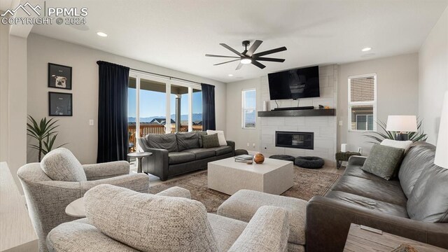 living room with a large fireplace and ceiling fan