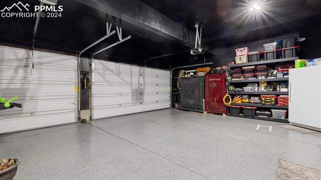 garage with a garage door opener and white refrigerator