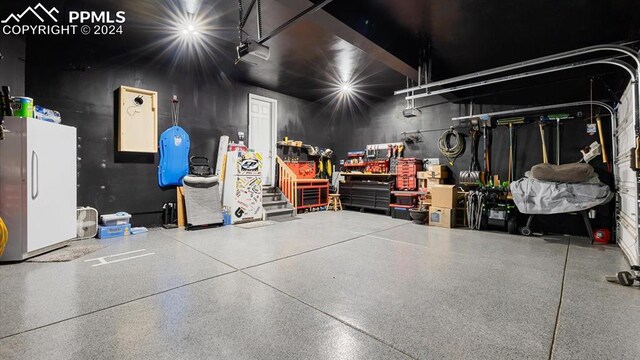 garage featuring a garage door opener and white refrigerator