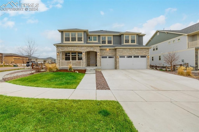 view of front of house with covered porch, a front yard, and a garage