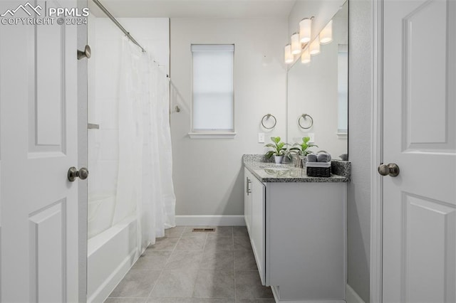 bathroom with tile patterned flooring, vanity, and shower / tub combo