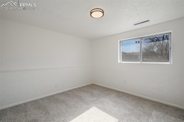 spare room featuring a textured ceiling and carpet