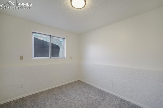 carpeted empty room featuring a textured ceiling