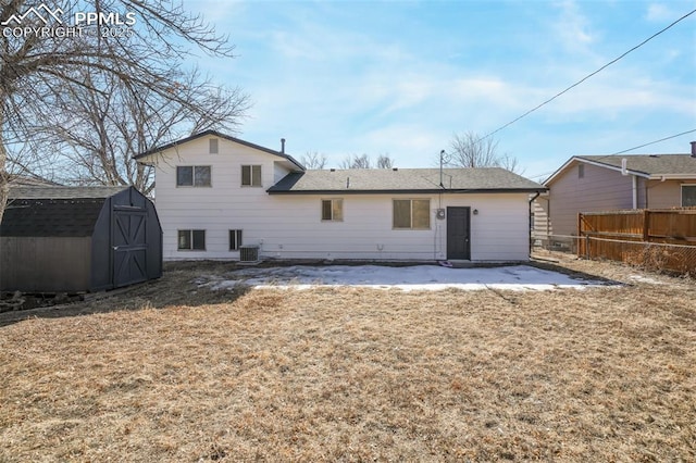 rear view of house with a shed, a yard, and central air condition unit