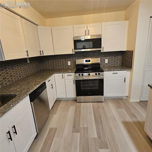 kitchen with white cabinets and appliances with stainless steel finishes