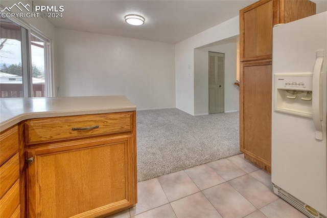 kitchen featuring white refrigerator with ice dispenser and light colored carpet