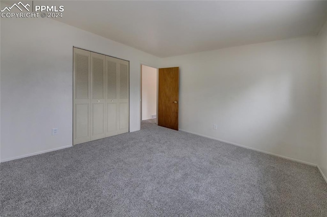 unfurnished bedroom featuring carpet flooring and a closet