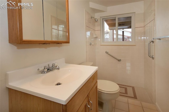 bathroom featuring tile patterned flooring, vanity, toilet, and walk in shower