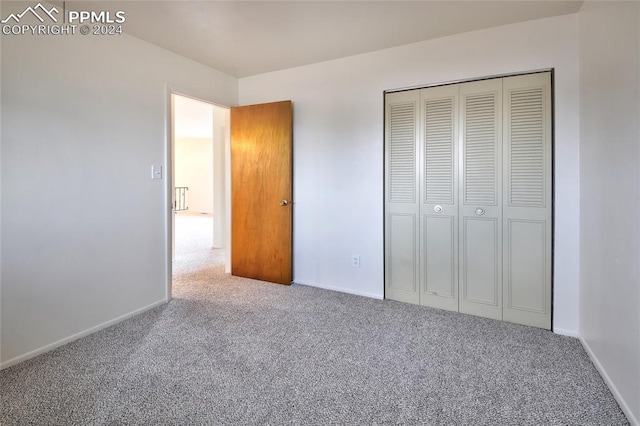 unfurnished bedroom featuring carpet flooring and a closet