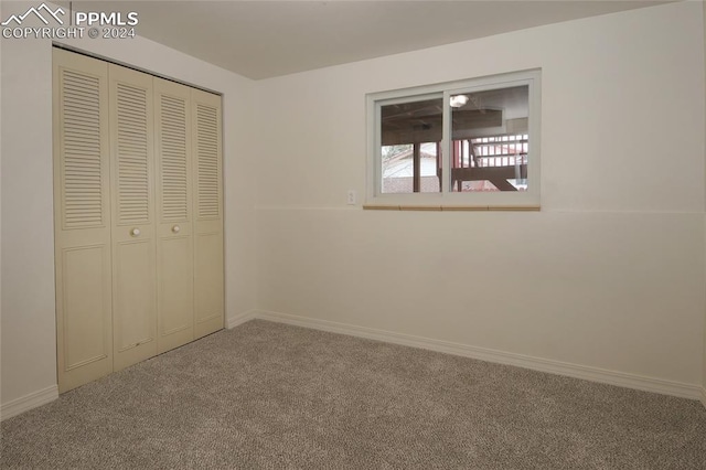 unfurnished bedroom featuring carpet flooring and a closet