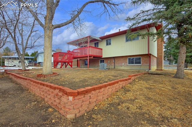 back of property featuring cooling unit and a wooden deck