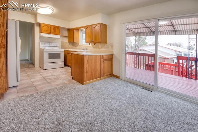 kitchen featuring light colored carpet, white appliances, backsplash, and range hood