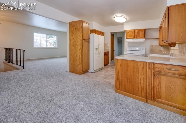 kitchen featuring white appliances, light colored carpet, tasteful backsplash, and sink