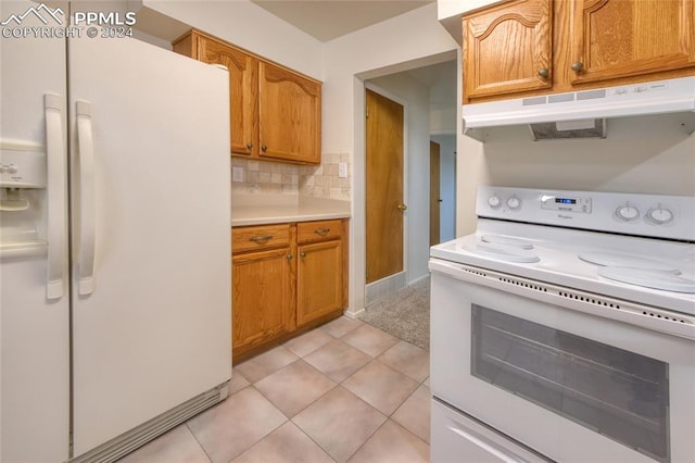 kitchen featuring decorative backsplash, light tile patterned flooring, and white appliances