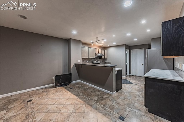 kitchen featuring kitchen peninsula, appliances with stainless steel finishes, and tasteful backsplash