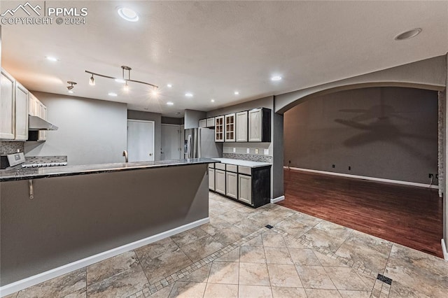 kitchen featuring white range oven, stainless steel fridge, and light hardwood / wood-style floors