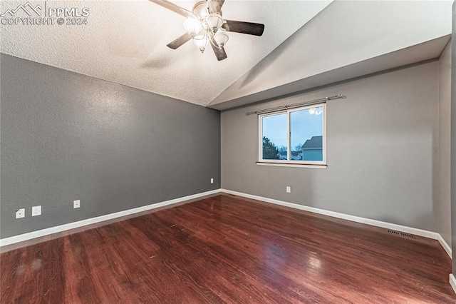 spare room with a textured ceiling, ceiling fan, hardwood / wood-style floors, and lofted ceiling