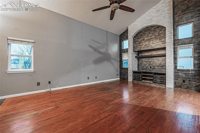 unfurnished living room featuring hardwood / wood-style floors, ceiling fan, a textured ceiling, and high vaulted ceiling