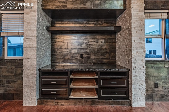 bar featuring dark brown cabinetry and dark hardwood / wood-style flooring