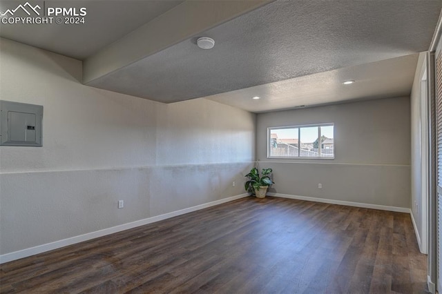 spare room with dark wood-type flooring and electric panel