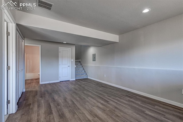 basement featuring dark hardwood / wood-style flooring and a textured ceiling