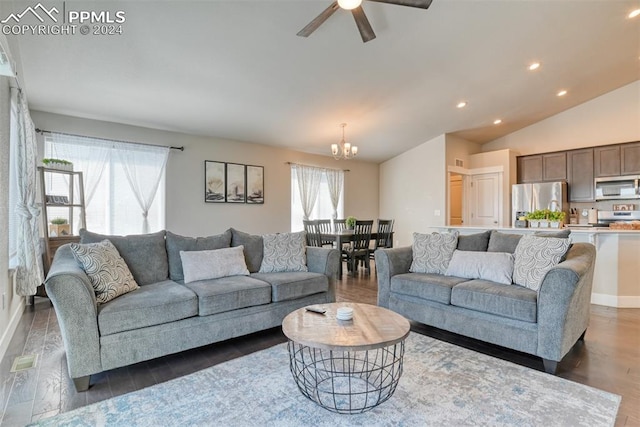 living room with dark hardwood / wood-style flooring, ceiling fan with notable chandelier, and vaulted ceiling