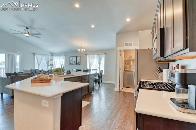 kitchen with plenty of natural light, dark brown cabinets, sink, and an island with sink