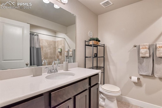 bathroom featuring tile patterned flooring, vanity, toilet, and walk in shower