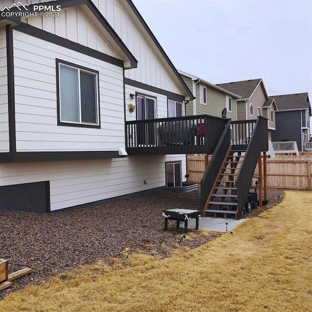 back of house featuring a wooden deck and a yard