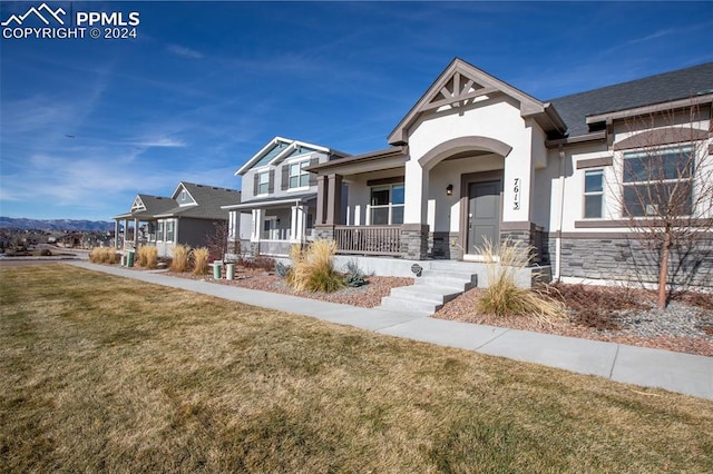 craftsman-style home featuring a porch and a front yard