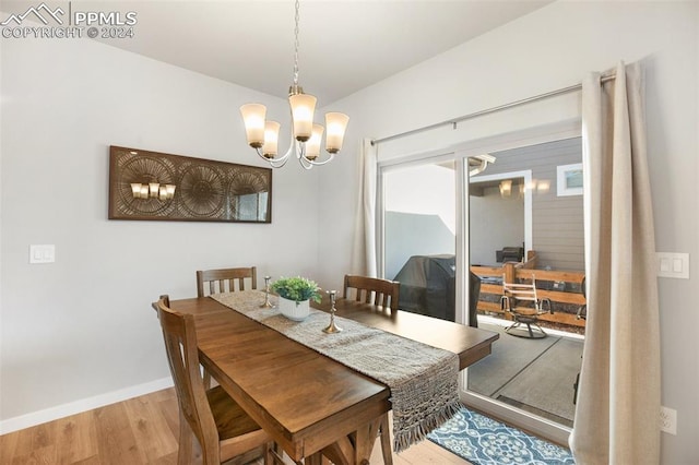 dining area with a notable chandelier and light hardwood / wood-style floors