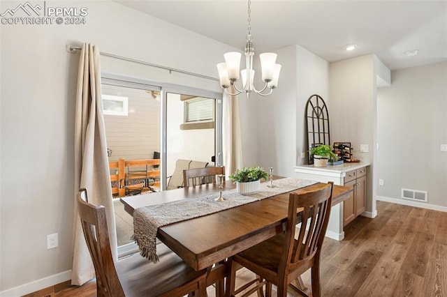 dining area with a notable chandelier and light wood-type flooring