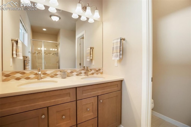 bathroom featuring tasteful backsplash, vanity, an enclosed shower, and toilet