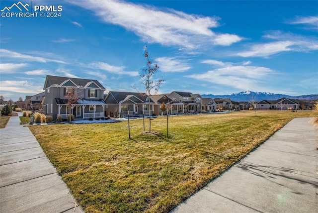 surrounding community with a lawn and a mountain view