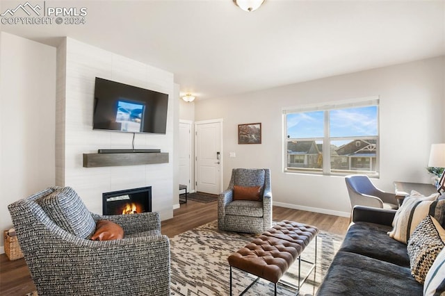 living room featuring hardwood / wood-style flooring and a tile fireplace