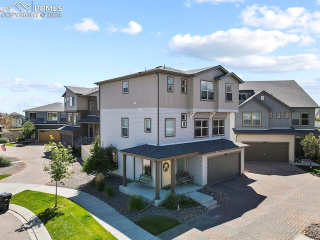 view of property featuring a porch and a garage