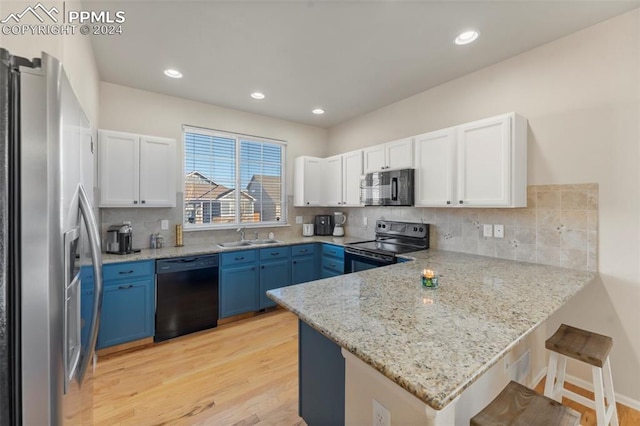 kitchen featuring black appliances, white cabinets, light wood-type flooring, blue cabinetry, and kitchen peninsula