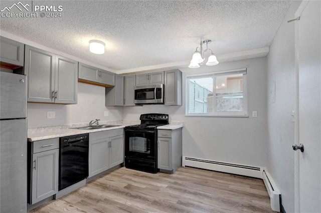 kitchen with pendant lighting, gray cabinets, light hardwood / wood-style flooring, and black appliances